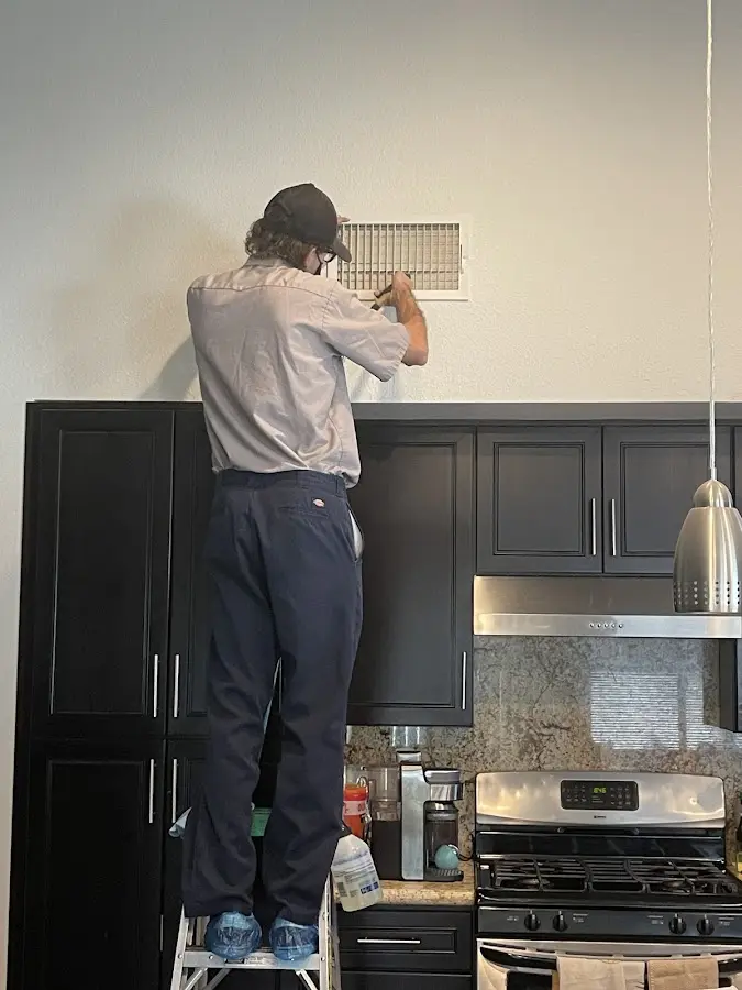 Technician inspecting an air vent during HVAC service in Muhlenberg